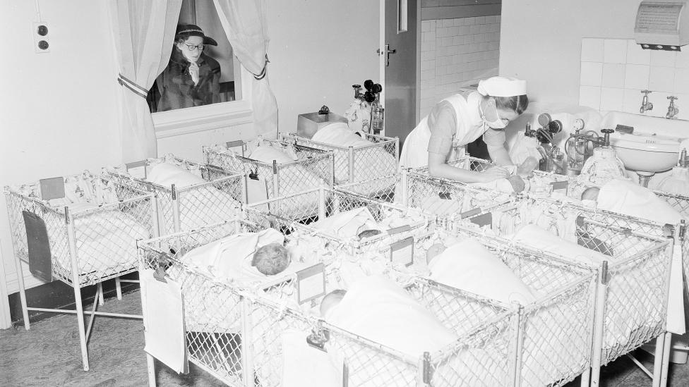 A crèche in a large metropolitan hospital with babies laying in small cots, 1954.