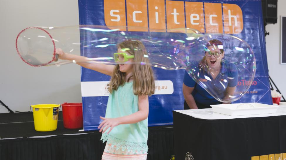 A child playing with a large bubble at Science Wonderland