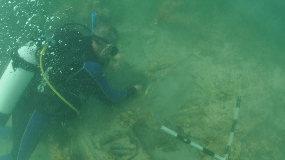 Western Australian Museum Maritime Archaeologist Michael ‘Mack’ McCarthy inspecting the wreck underwater at 7 Mile Beach