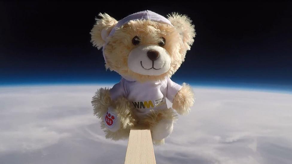 Nugget the teddy bear floating above the curvature of the Earth