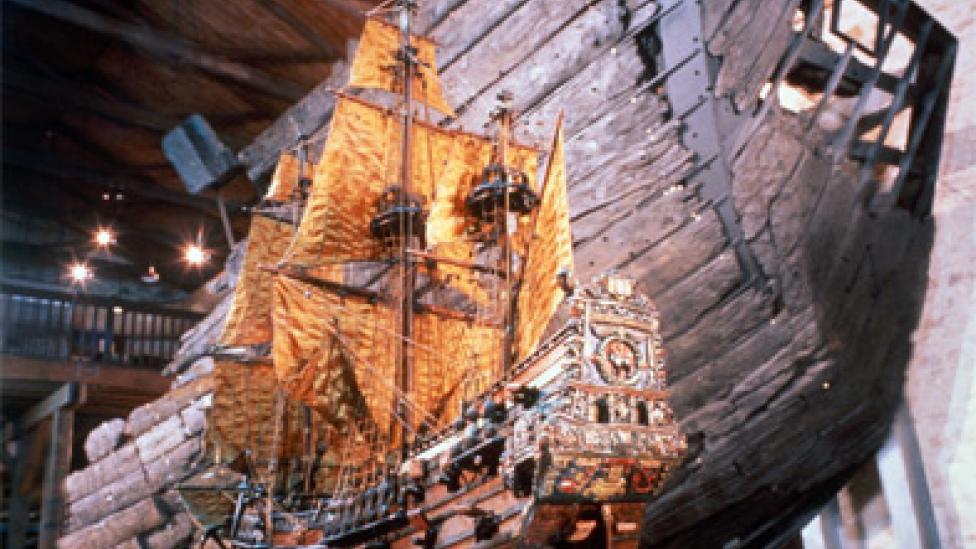 A large model of a ship next to the restored hull of the original vessel