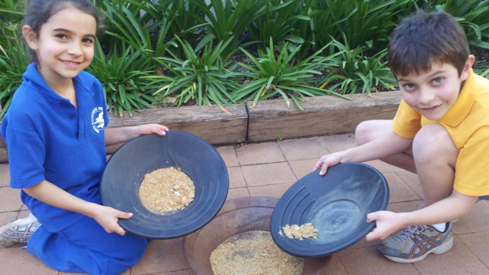 Two children sifting through gravel