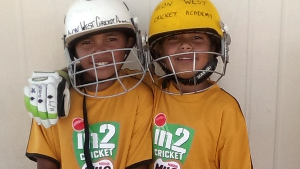 Two children posing together in their sports uniforms