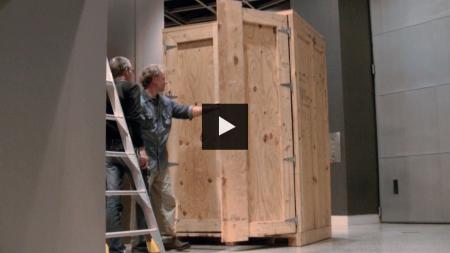 Two people working on opening an exhibition storage case